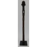 Tribal Art: An African carved hardwood axe handle. One end terminating with a carved head. Displayed