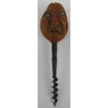 A Victorian novelty corkscrew with grotesque faced handle . The coquilla nut handle carved as a