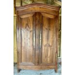 An 18th century French fruitwood armoire of good colour, with polished brass hinges and lock