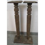 A pair of antique mahogany plant stands, with fluted and spiral carved columns, on plinth bases. H96