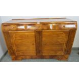 An Art Deco walnut sideboard, housing three short drawers above two cupboards, with phenolic