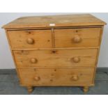 An antique pine chest of two short over two long drawers with turned knob handles, on turned