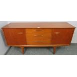 A mid-century teak sideboard by Jentique, having three short drawers flanked by two cupboards with