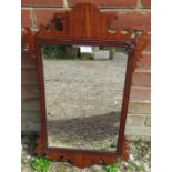 A Georgian mahogany wall mirror, within a shaped surround. H69 W42 Condition report: Minor veneer