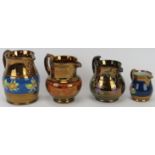 A group of four Victorian copper lustre jugs, 19th century. Comprising a copper lustre mask jug