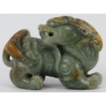 A Chinese celadon and russet jade Buddhistic lion, 20th century. 7 cm length. Provenance: Private