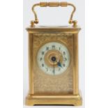 A Swiss gilt brass cased carriage clock, 19th century. With a foliate engraved gilt mask, cream