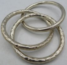 Two hand beaten and one plain white metal bangle, as one bracelet. Approx weight 88 grams. Condition