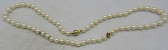 An Akoya cultured pearl necklace individually knotted, approx: 7mm across, with 14ct gold ball clasp