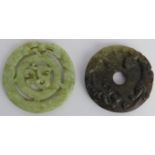 Two Chinese celadon and russet jade carved discs, 20th century. One carved as a bi disc with