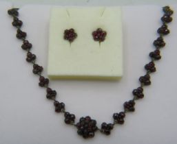 An antique garnet necklace. Approx: 16" long and a pair of garnet flower shaped earrings. 15