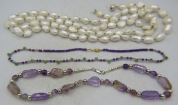 A large fresh water pearl necklace interspersed with white metal beads and having a white metal ball