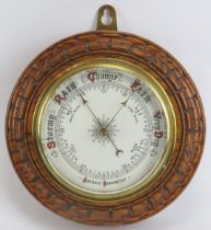 A British aneroid barometer, late 19th/early 20th century. With enamelled dial and mounted on an oak