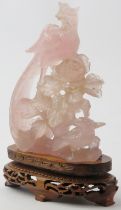 A Chinese carved rose quartz figure of birds perched on a peony branch, 20th century. Modelled on