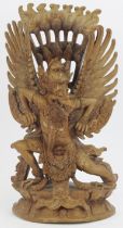 A South East Asian carved wood sculptural figure of the Hindu god Garuda, 20th century. Probably