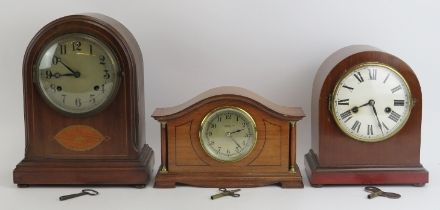 A group of three mahogany and oak mantle clocks, early/mid 20th century. Comprising two domed clocks