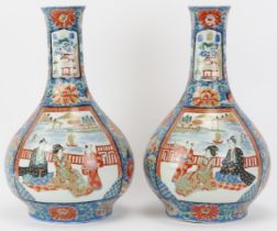 A pair of Japanese Arita porcelain bottle vases, late Meiji period. Both enamel decorated with