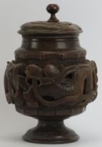 An Indochinese carved wood tea caddy, early 20th century. Carved with dragons to the central band