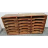 An early 20th century wall mounting bank of pitch pine shelves, formerly from a post office,