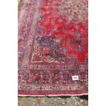 A fine 20th century Persian carpet with central motif on a rich red ground. 400 cm x 282 cm.