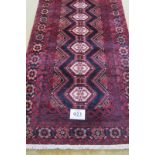 A North East Persian meshed Belouch rug, on deep red ground. 289cm x 197cm. Condition report: In