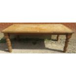 A substantial antique pine farmhouse kitchen table, the planked top raised on chunky baluster turned