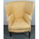 A 19th century porter’s chair, having a barrel back and scrolled armrests, upholstered in yellow