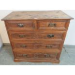 An 18th century and later elm chest housing two short over three long drawers with relief carving