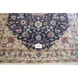 A good quality Persian rug with a central round motif on blue ground and cream floral deep borders