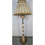 An ornate vintage brass and ceramic height adjustable standard lamp, on a circular plinth base