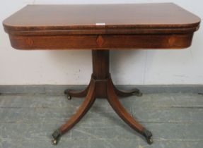A Regency Period rosewood turnover card table, having crossbanded inlay, on an octagonal column with