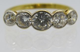 An 18ct yellow gold five stone graduated collet set brilliant cut diamond ring, size N/O. Centre