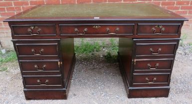 A 19th century style pedestal desk, the top with inset tooled green leather, having a