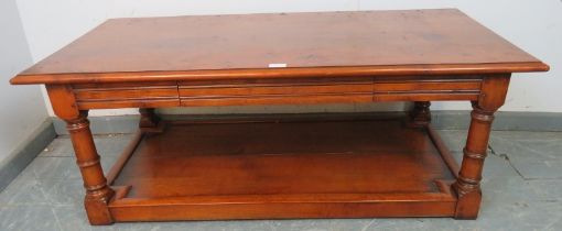 A good quality cherrywood rectangular coffee table with single blind drawer, on turned and block