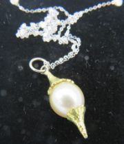 A bespoke Australian Golden Southsea pearl pendant set between planished yellow metal mounts. The