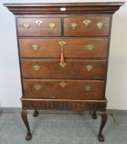 An 18th century oak chest on stand, housing two short over three long drawers with fancy brass