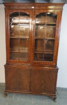 An antique flame mahogany tall glazed bookcase, the tracery doors opening onto three height