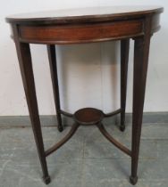 An Edwardian mahogany occasional table strung with ebony, on tapering square supports united by a