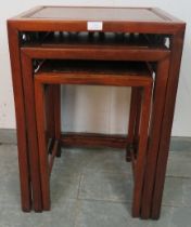 A set of three Chinese walnut nesting tables, with fielded burr walnut inset tops and foliate