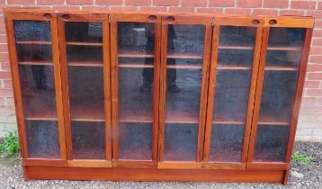 A vintage Scandinavian hardwood low glazed bookcase the six doors with recessed handles opening onto