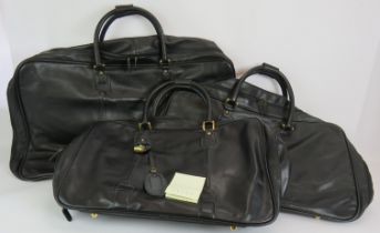 A set of three Gucci style graduated travel holdalls in black leather. With stitched horse bit