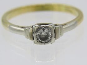 An unmarked white and yellow metal ring set with centre diamond, approx 0.10cts, size O, boxed.