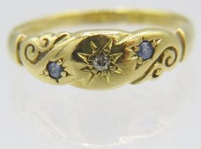 An 18ct yellow gold engraved gypsy ring set with small centre diamond and topaz either side, size R.