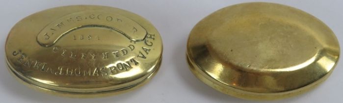Two Welsh miner’s brass snuff boxes, late 19th century. Both of oval form with hinged covers, one
