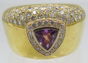 A heavy 18ct yellow gold ring set with centre pink trillion cut sapphire surrounded by bands of
