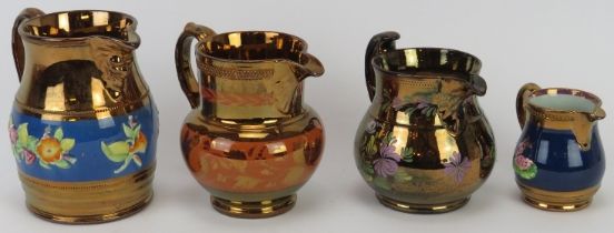 A group of four Victorian copper lustre jugs, 19th century. Comprising a copper lustre mask jug