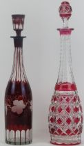 A European cranberry and clear overlay cut glass decanter and a flash ruby etched and cut glass