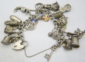 A silver link charm bracelet with silver padlock clasp and 26 various charms, some silver and some