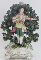 A Samson of Paris gilt and polychrome painted porcelain figurine of a fruit seller with bocage, 19th