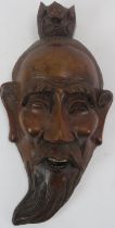 A Japanese carved hardwood mask, late Meiji period. With inset bone teeth. 28.4 cm height. Condition